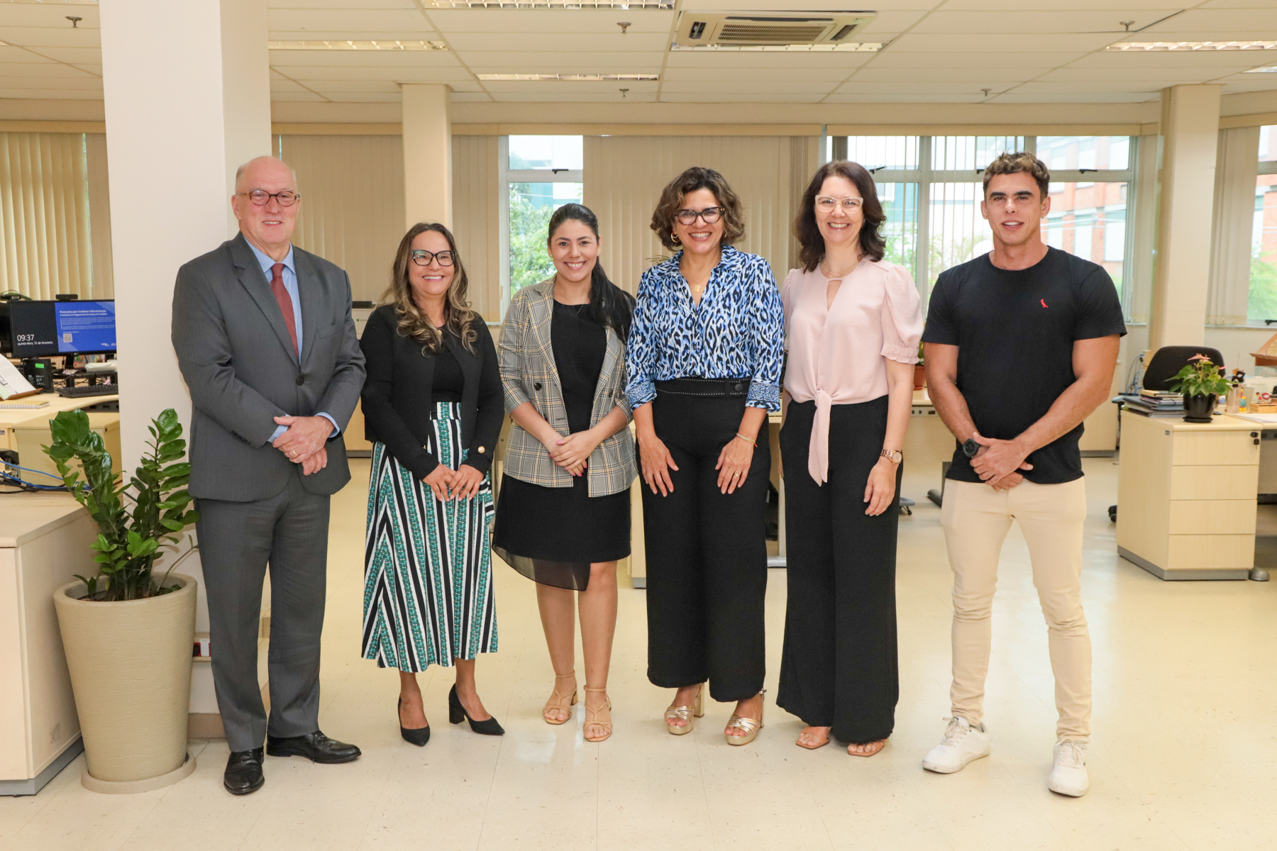 Foto posada na EJud. Estão em pé, lado a lado: Des. Martins Costa, Desa. Maria Cesarineide, Flávia Cristina Morais, Desa. Ana Paola Diniz, Amoni Lavigne e Carlos Santiago