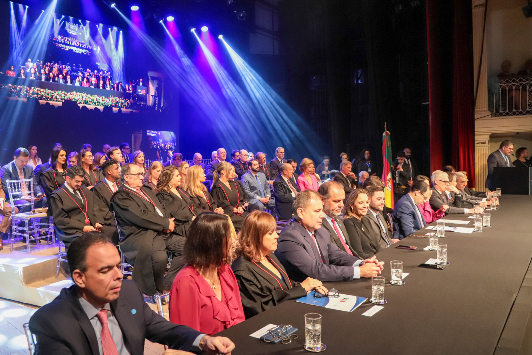 Foto da mesa oficial e do espaço de autoridades, no palco do Theatro São PEdro