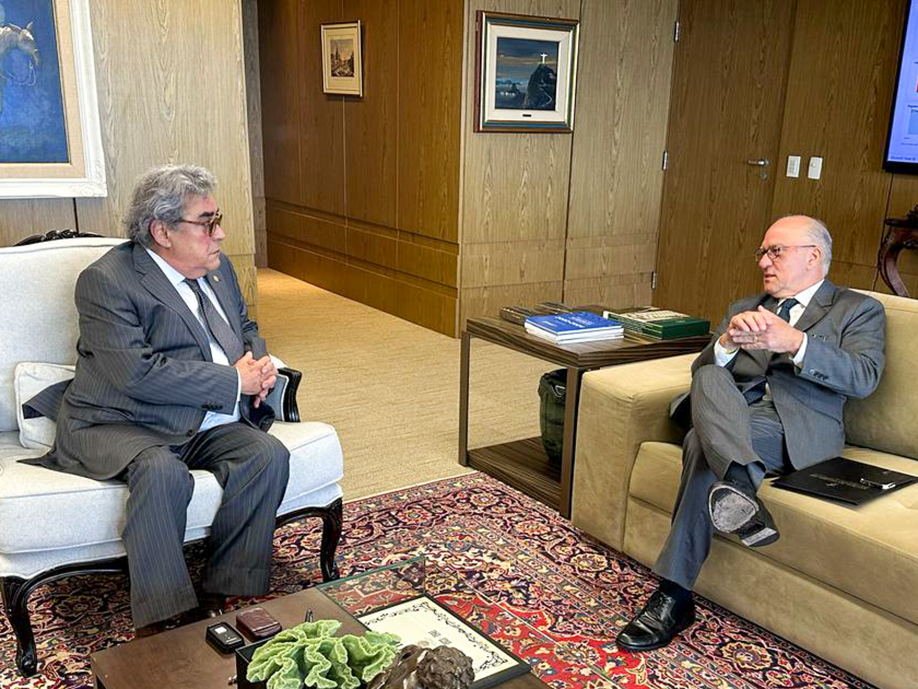 Des. Martins Costa conversando com o ministro Aloysio, no gabinete do presidente do TST. Ambos estão sentados em poltronas.