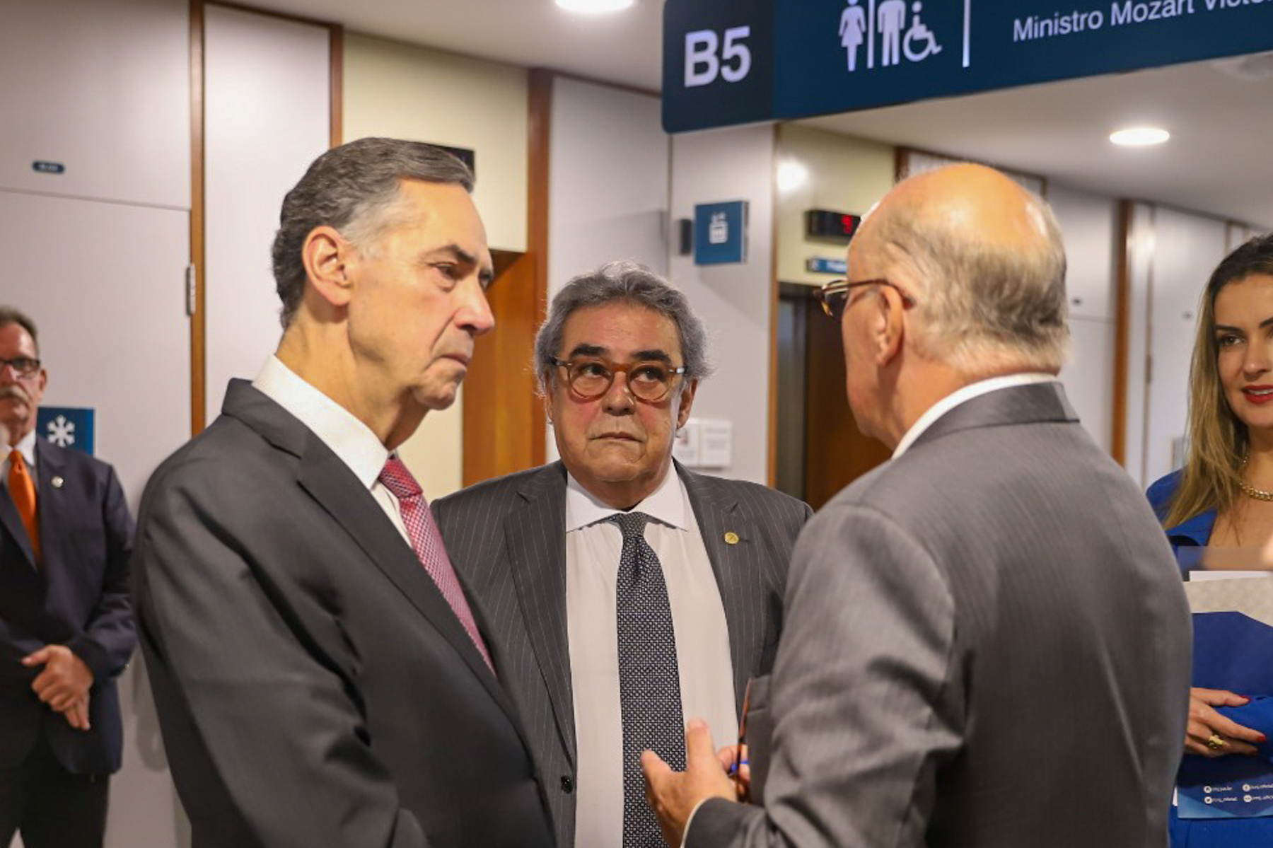Presidente Ricardo Martins Costa conversando com ministros Barroso e Aloysio. Eles estão em pé.