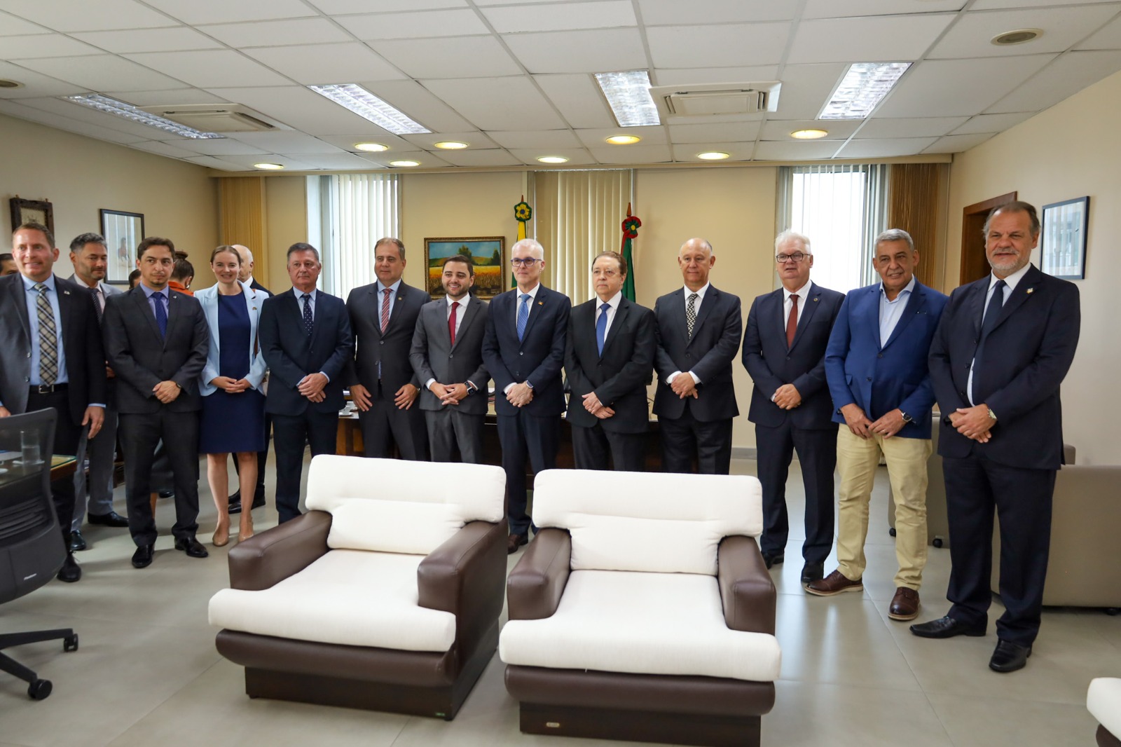 A imagem mostra diversas autoridades posando para foto, no gabinete da Presidência do TRE-RS.