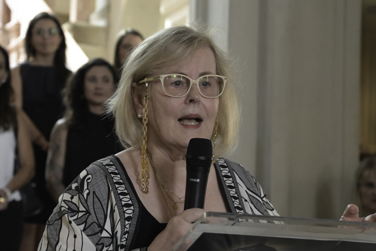 Rosa Weber é branca, loira e usa óculos. Usa vestido com estampas em preto e branco.  