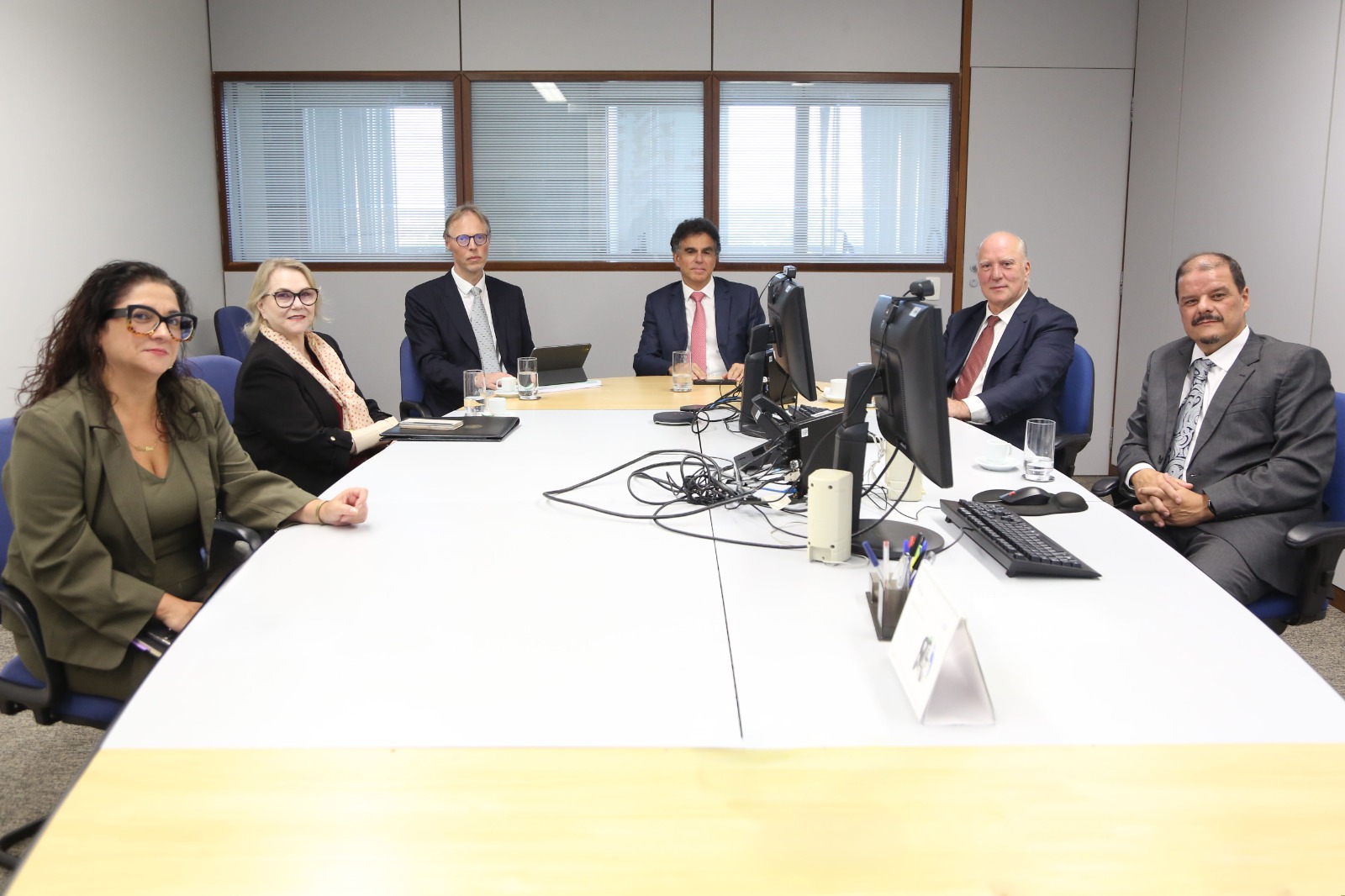 A foto mostra seis pessoas reunidas em uma sala de reuniões, sentadas ao redor de uma mesa com computadores e documentos. São os desembargadores Ricardo Martins Costa e Laís Helena Jaeger Nicotti, além ministro Vieira de Mello Filho, o juiz auxiliar da Corregedoria do TRT-RS, Daniel Souza de Nonohay, a assessora da Presidência Carolina Ferreira e o juiz auxiliar da Corregedoria-Geral da Justiça do Trabalho, Giovanni Olsson.
