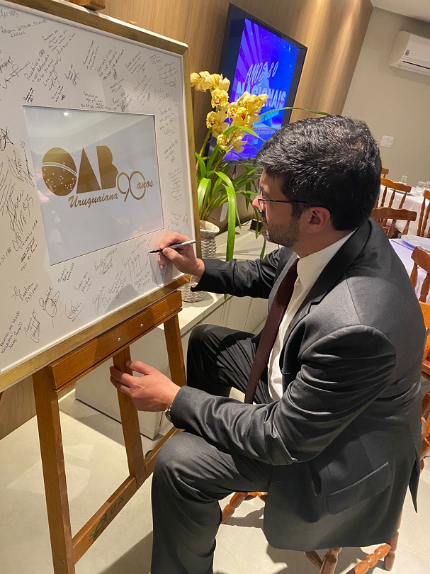 Des. Rossal assinando quadro comemorativo aos 90 anos da OAB Uruguaiana