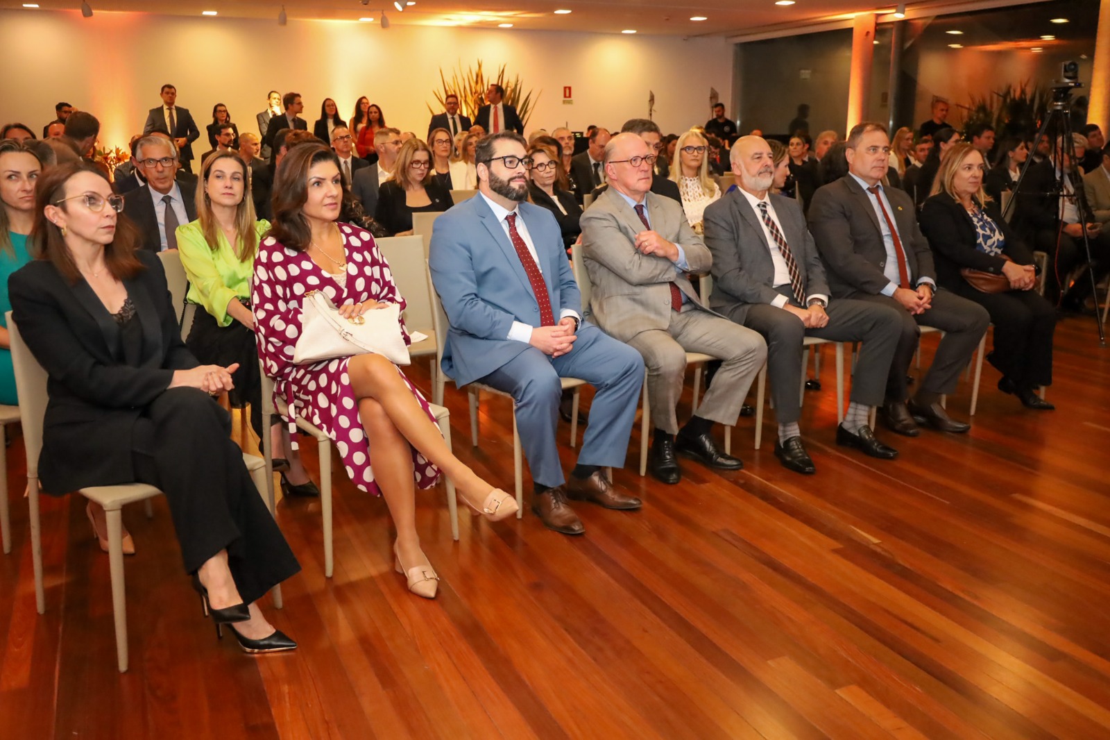 A foto em 1º plano onde aparece o público acompanhando cerimônia. No meio, aparecem os desembargadores Martins Costa e Alexandre.