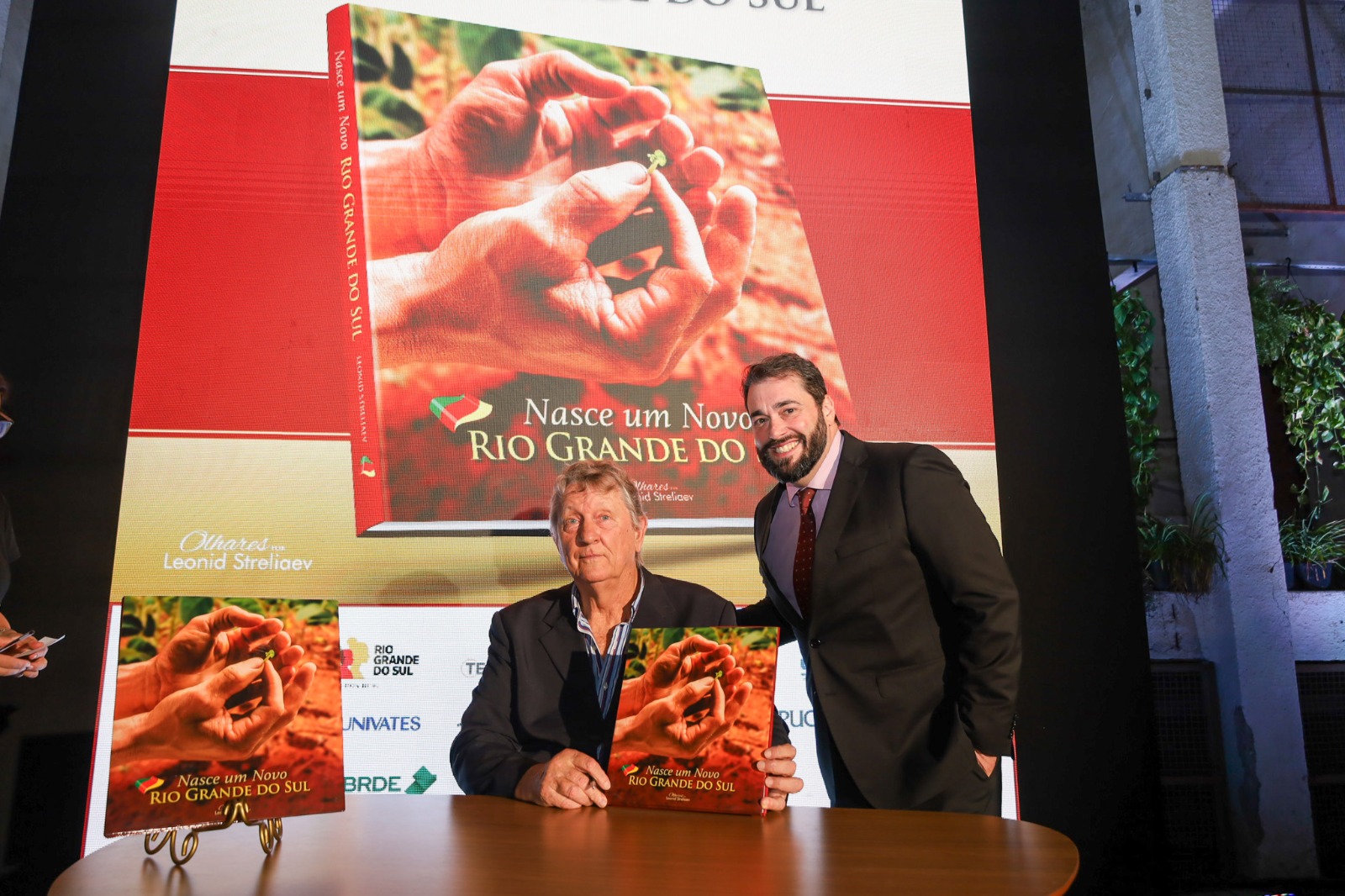 Foto posada do desembargador Alexandre e de Leonid com o livro na mão após autófago.