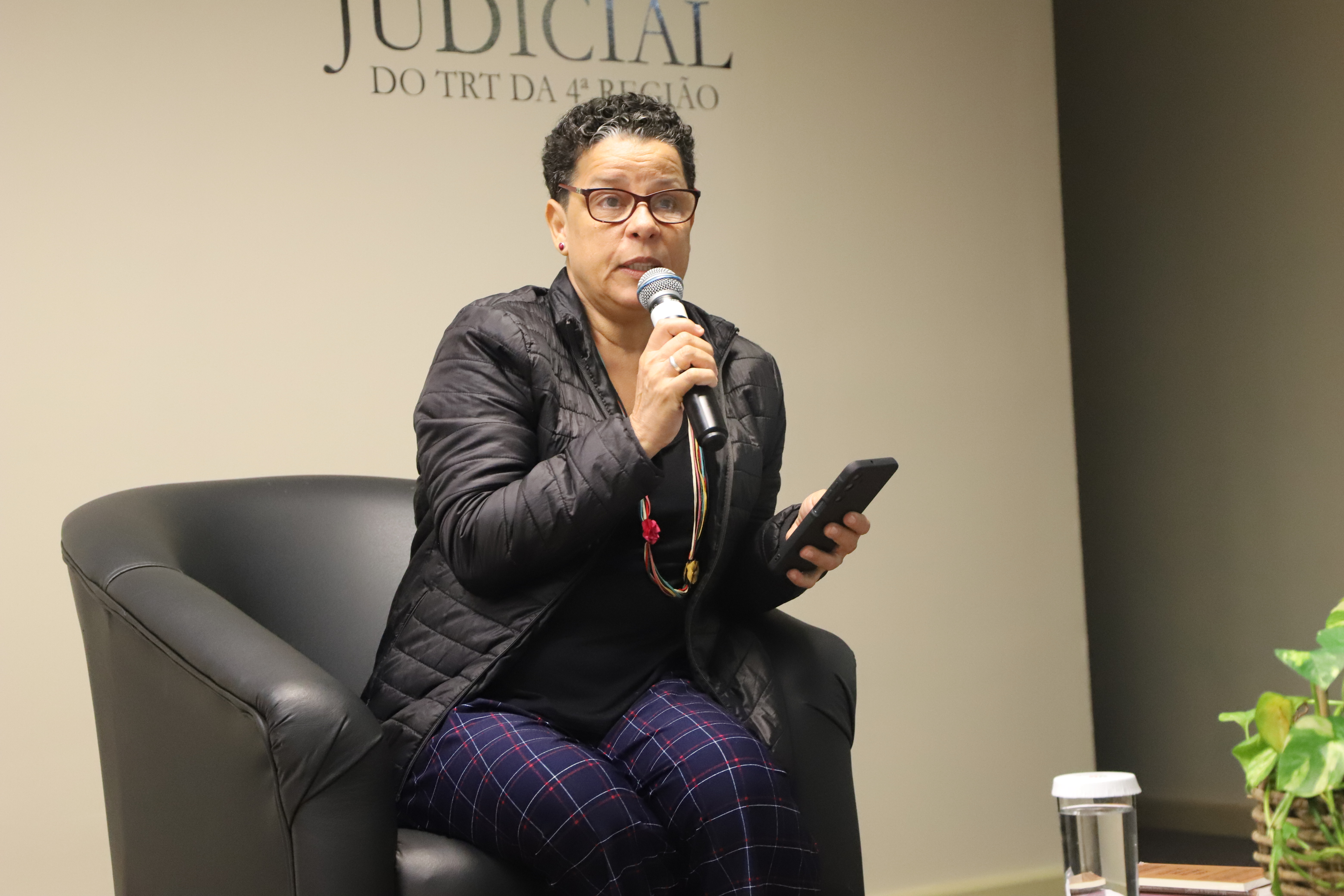 Escritora Dalva na poltrona no palco fazendo sua fala