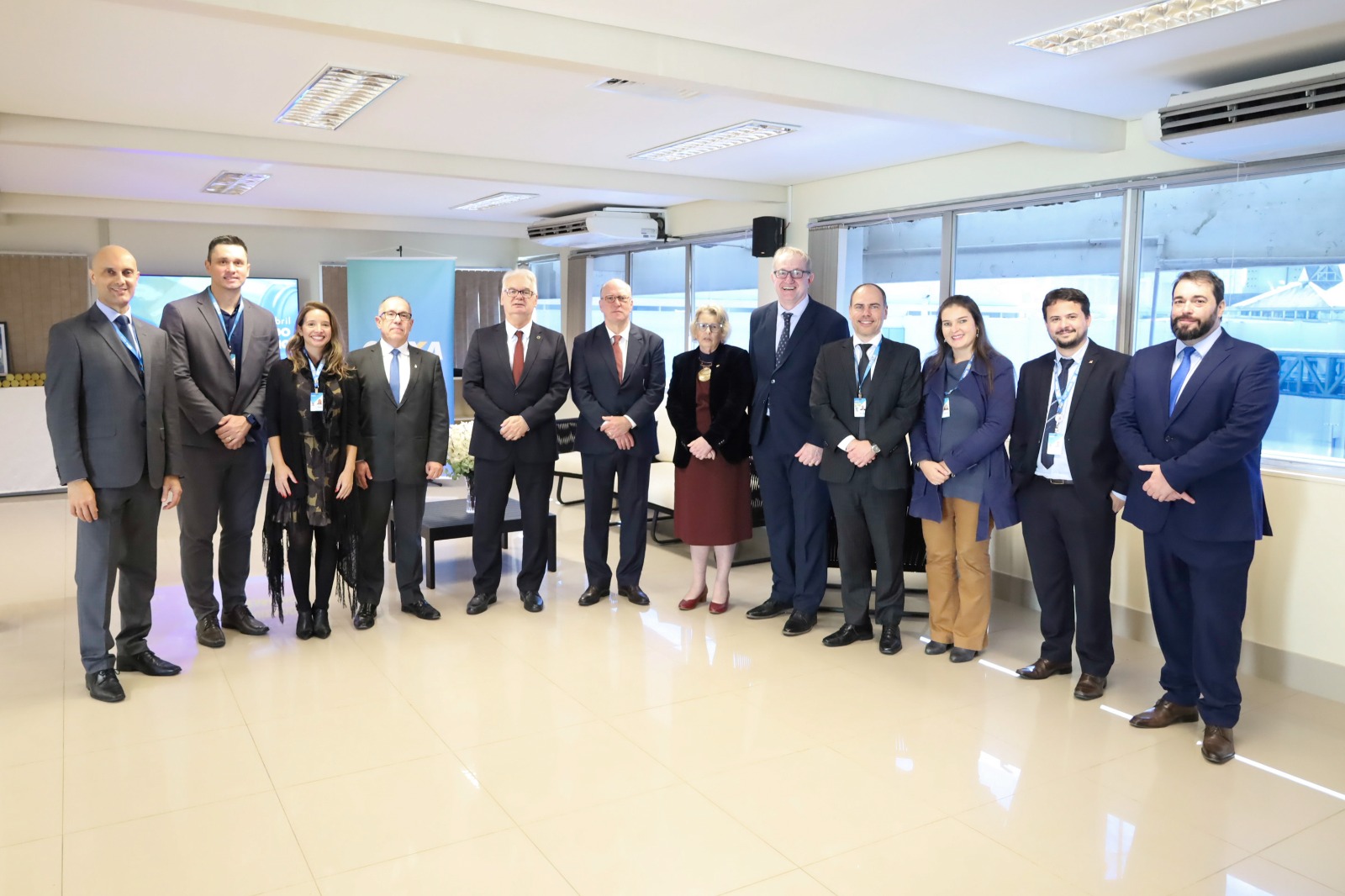Diversas pessoas aparecem perfiladas posando para a foto sorrindo.