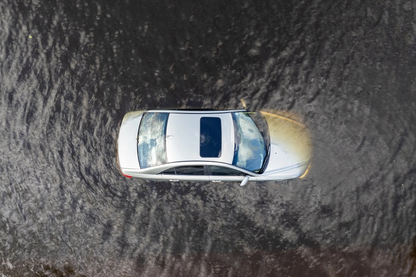 Foto ilustrativa de um carro em local alagado. O carro está quase completamente submerso.