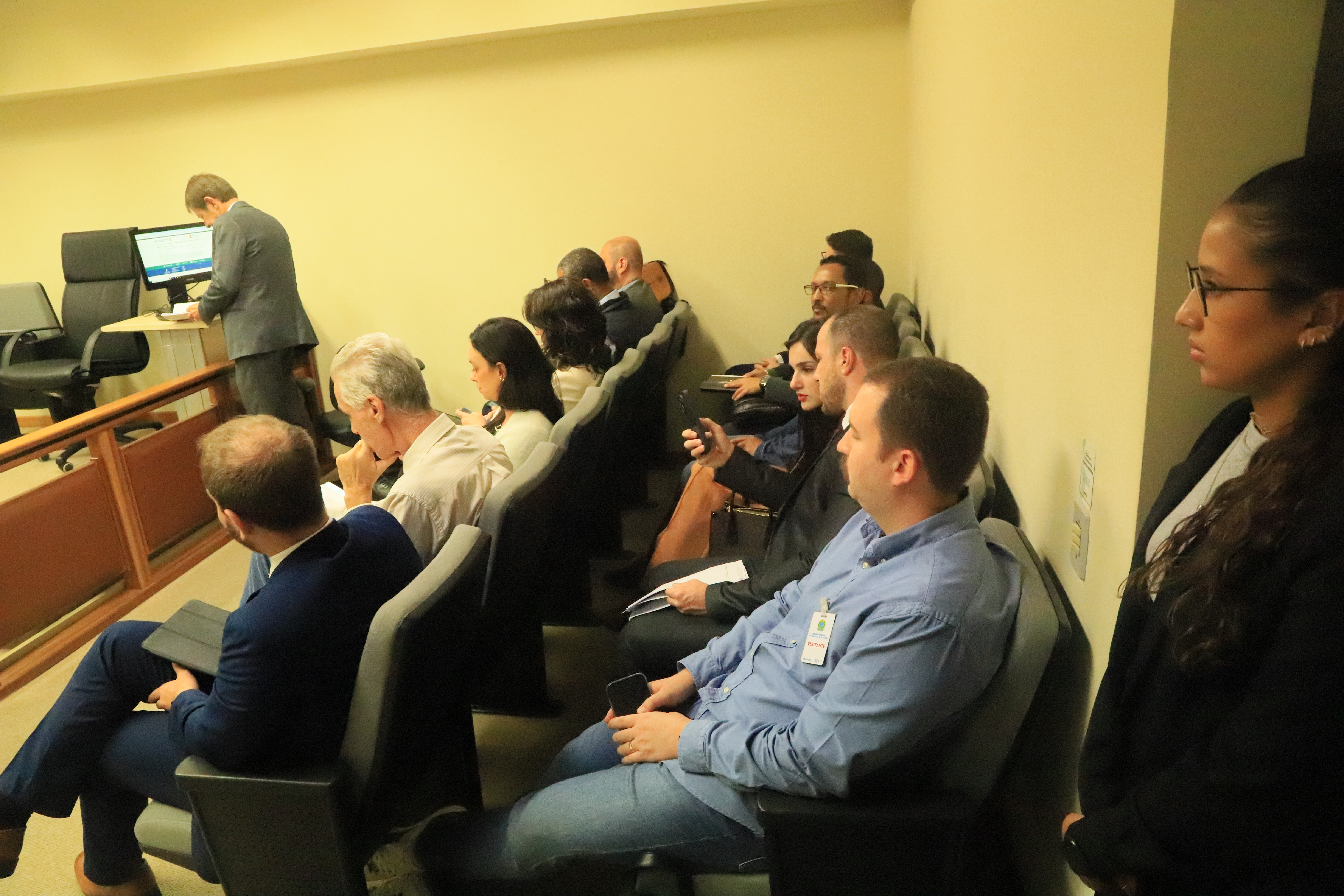 Alunos e professores assistem a uma sessão na sala de julgamento. No fundo, desembargadores e advogados.