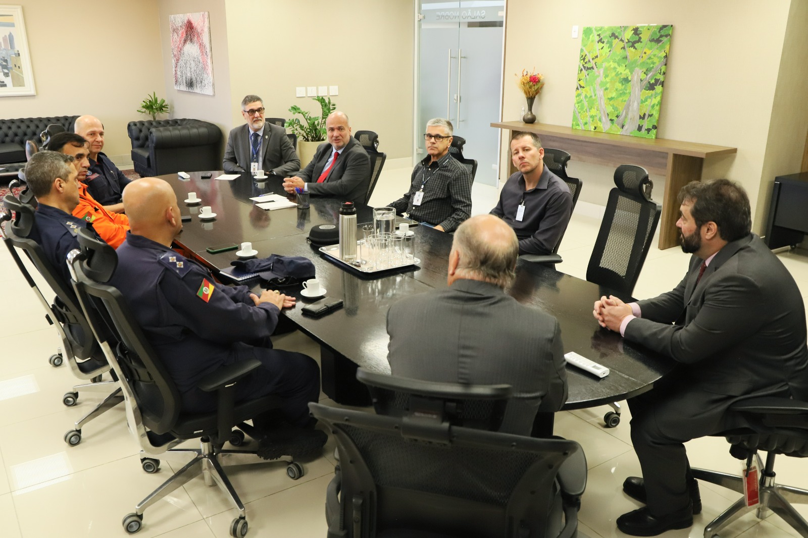 Participantes na mesa de reunião no Salão Nobre, vistos pelo ângulo inverso.