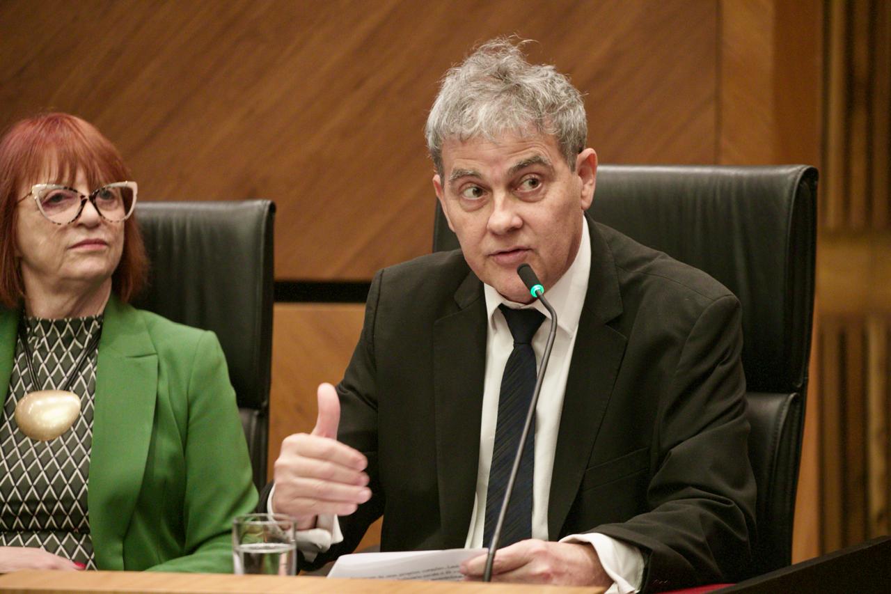 desembargador Ricardo Carvalho Fraga, fala ao microfone durante a cerimônia de abertura da Semana da Conciliação Trabalhista. Ao lado dele, a vice corregedora do TRT-RS, desembargadora Maria Madalena Telesca.