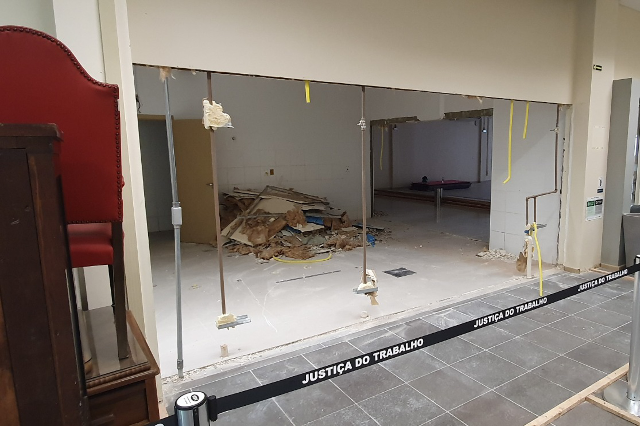 Fachada sem o vidro. Ao fundo aparece a sala em obras, com entulhos. na frente do espaço há uma faixa estendida para impedir o acesso de pessoas.