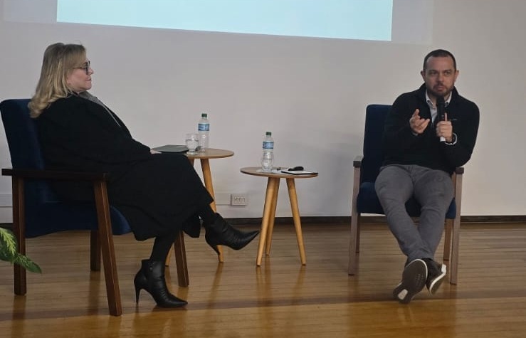 Dra. Laís e dr. Bruno palestrando no palco