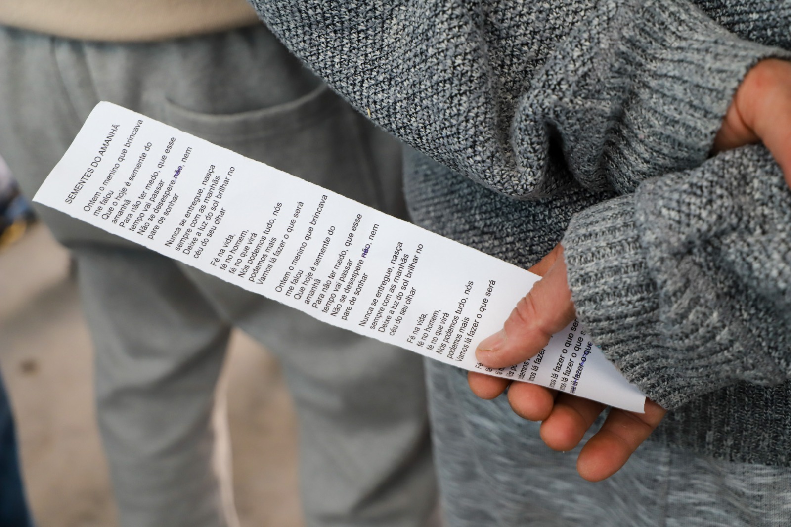 A foto mostra um papel com a letra da música cantada.