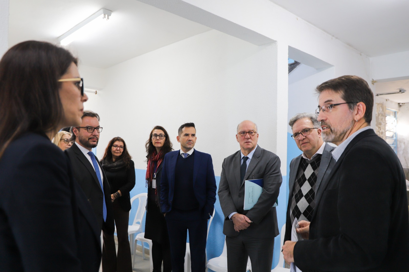 A foto mostra área interna da Apac, com pessoas conversando.