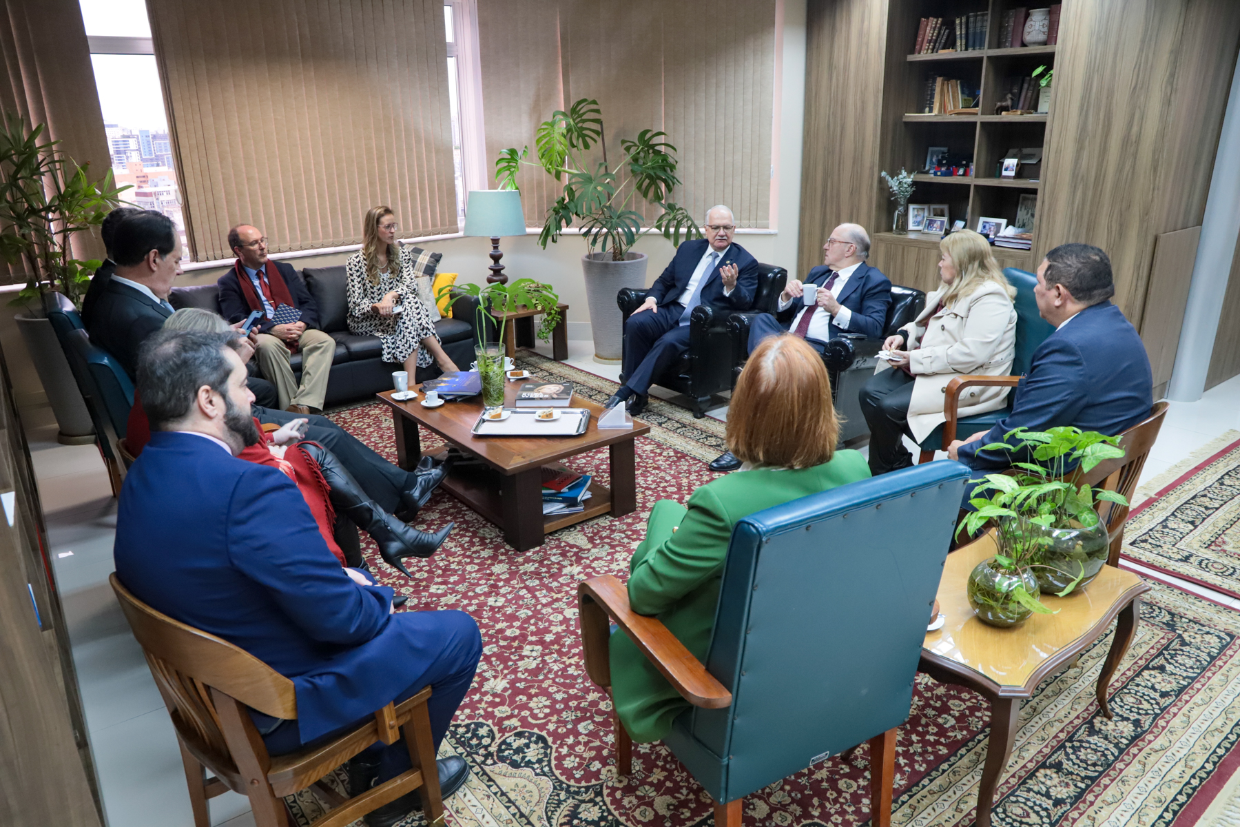 foto em ângulo aberto da reunião no gabinete, mostrando todos os participantes sentados, conversando