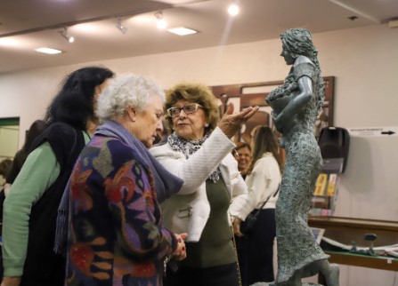 Três senhoras apreciando uma das esculturas expostas