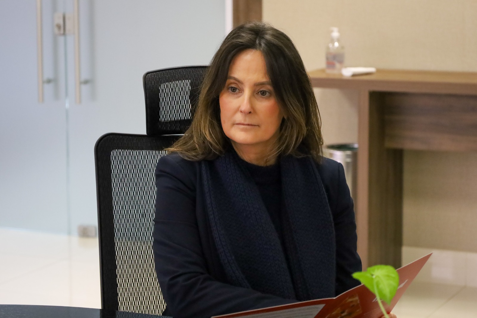 A foto mostra a juíza Luciana sentada.