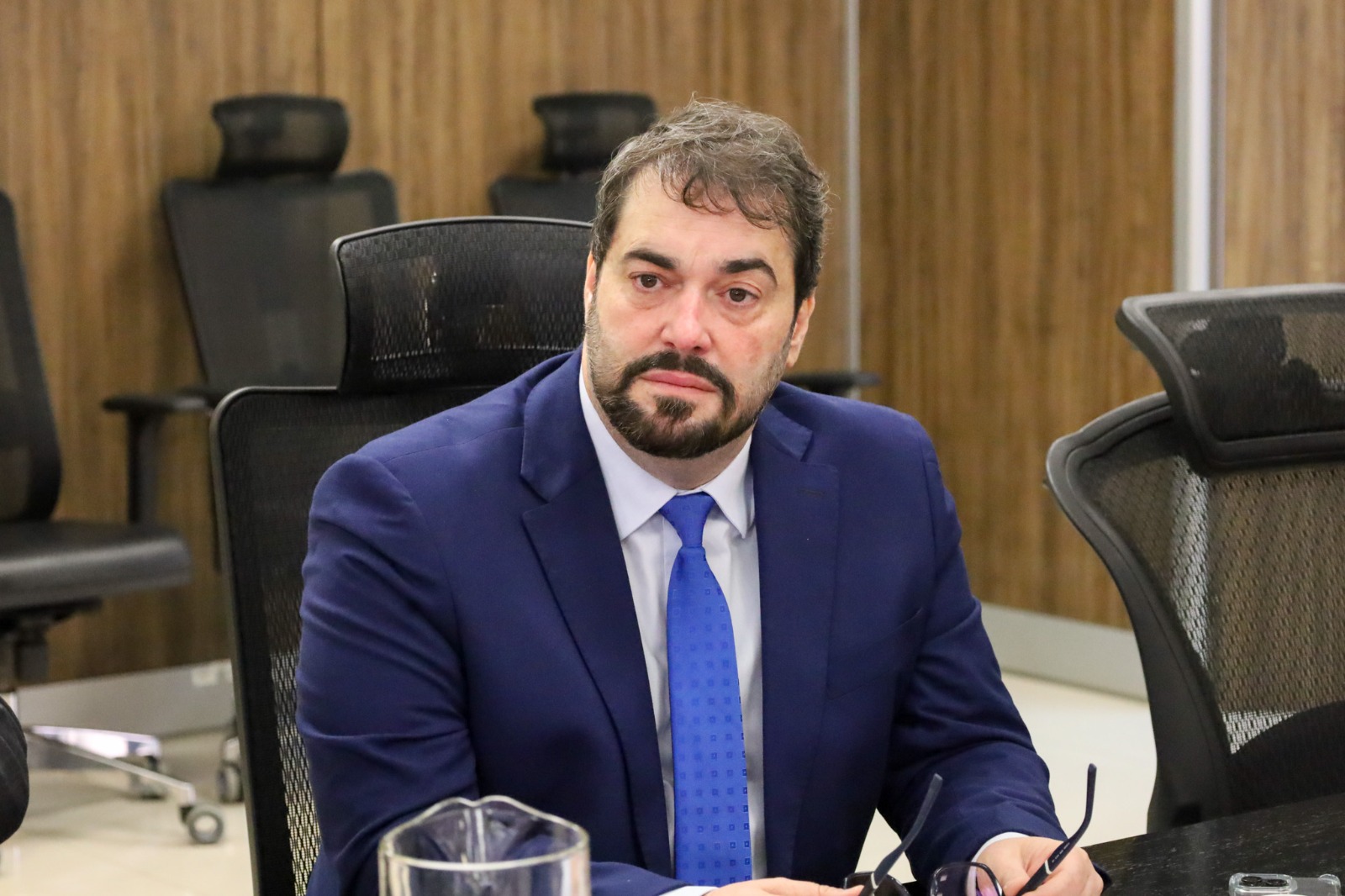 A imagem mostra o desembargador Alexandre sentado.