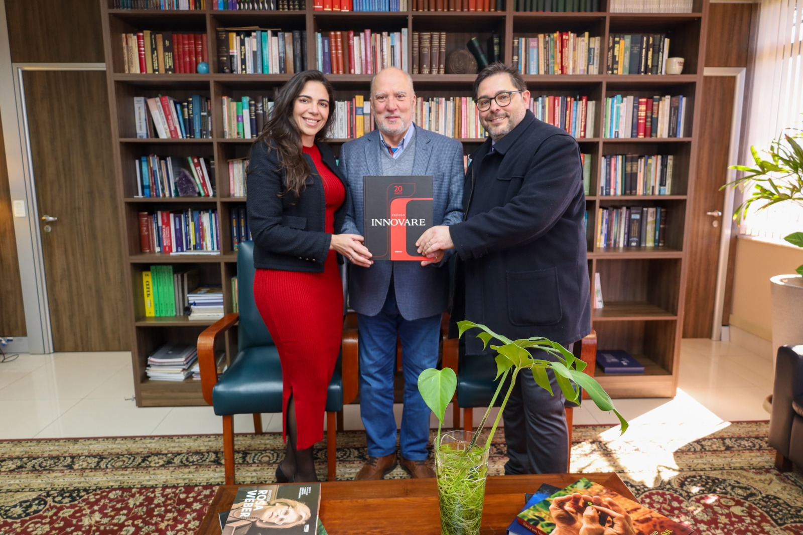 Foto mostra consultores do Innovare entregando livro ao presidente.