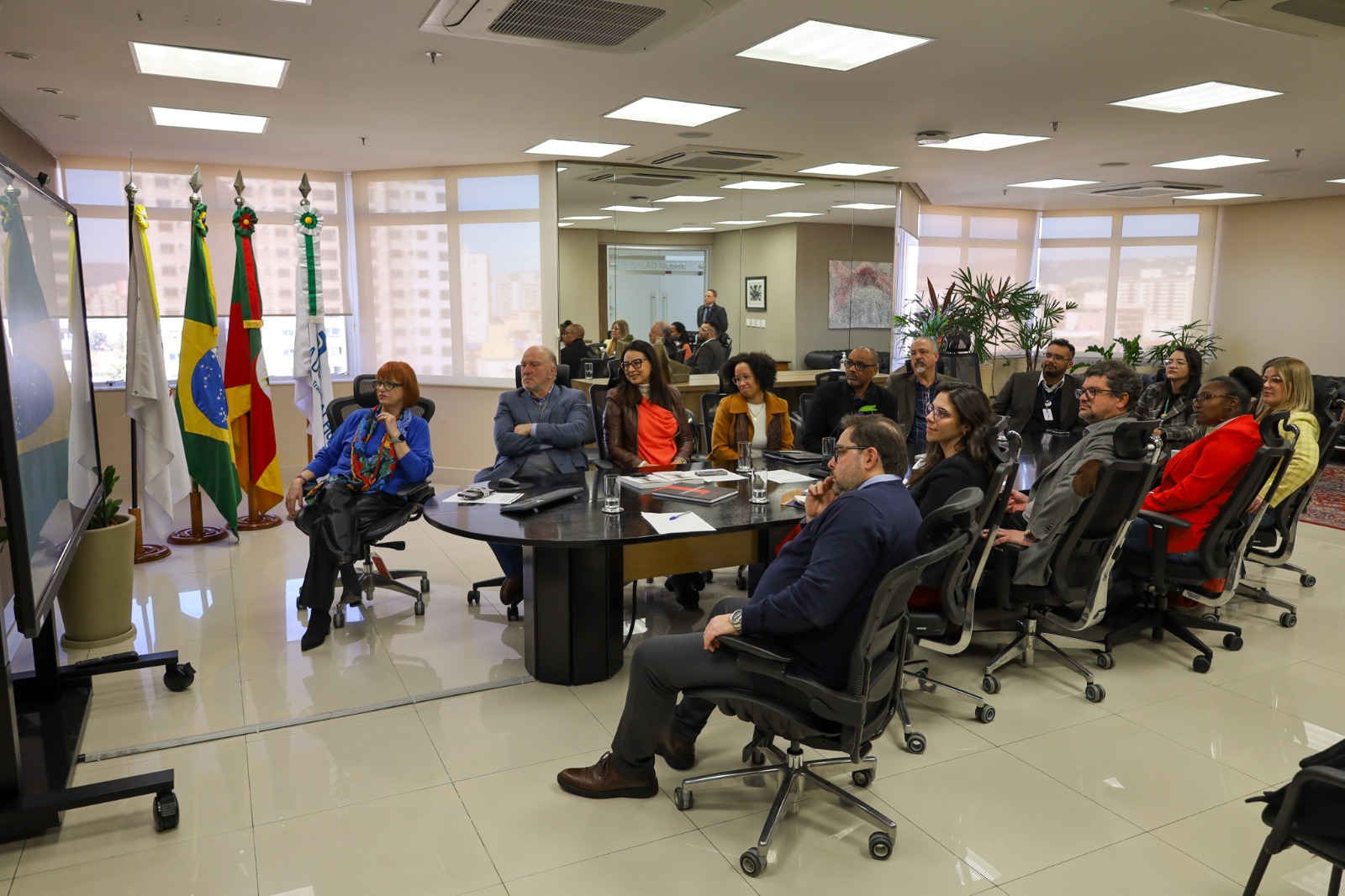 A foto mostra os presentes olhando documentário.