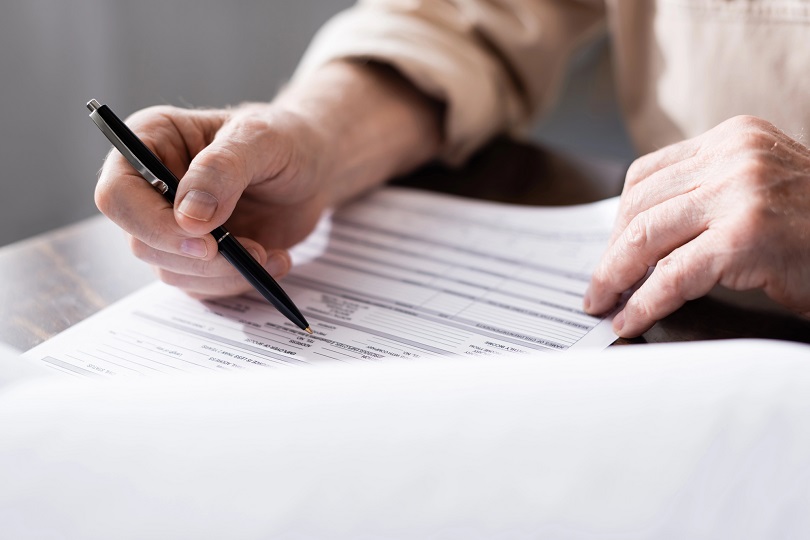 Foto ilustrativa de um homem segurando um documento nas mãos