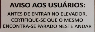 Placa de elevador, dizendo: Aviso aos usuários: antes de entrar no elevador, certifique-se de que o mesmo não encontra-se parado neste andar.