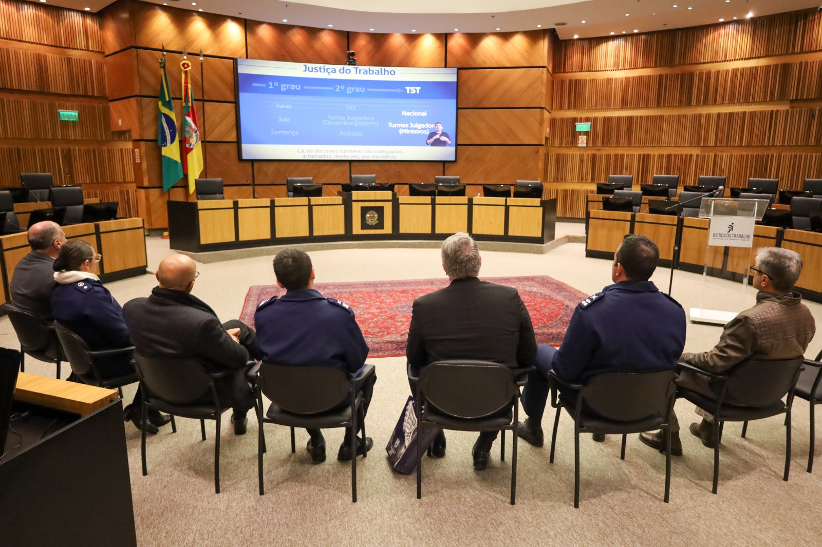 A foto mostra a comitiva vendo vídeo TRT-RS