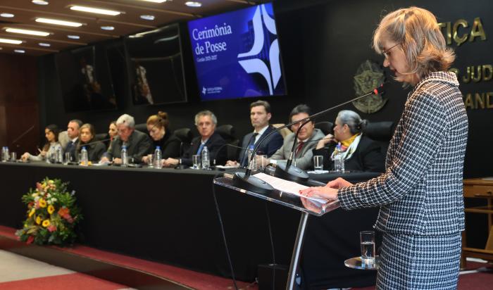 Juíza Ingrid Schroder Sliwka discursa durante a cerimônia de posse como diretora do Foro da Justiça Federal do RS, acompanhada por autoridades na mesa solene.