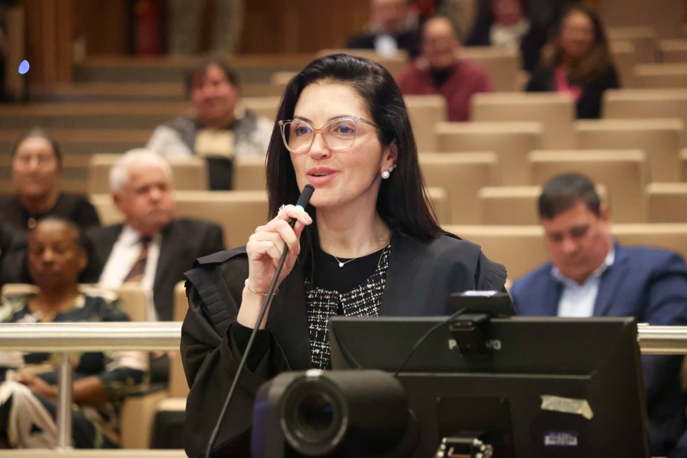 A foto mostra a advogada Márcia discursando.