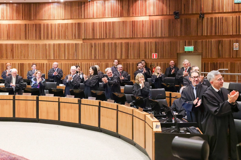 A foto mostra desembargadores batendo palmas.