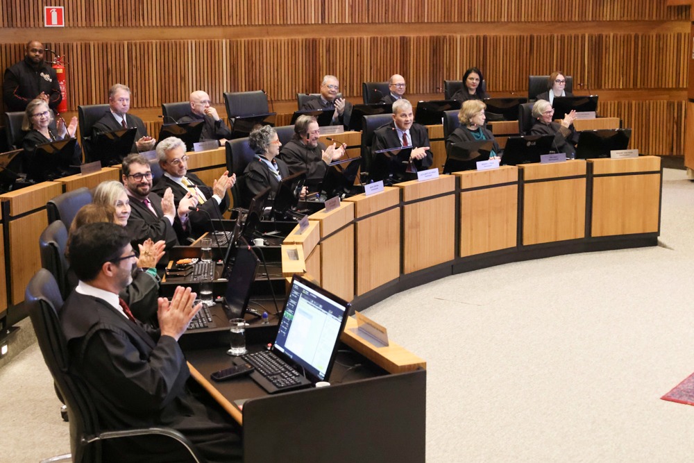 A foto mostra desembargadores batendo palmas.