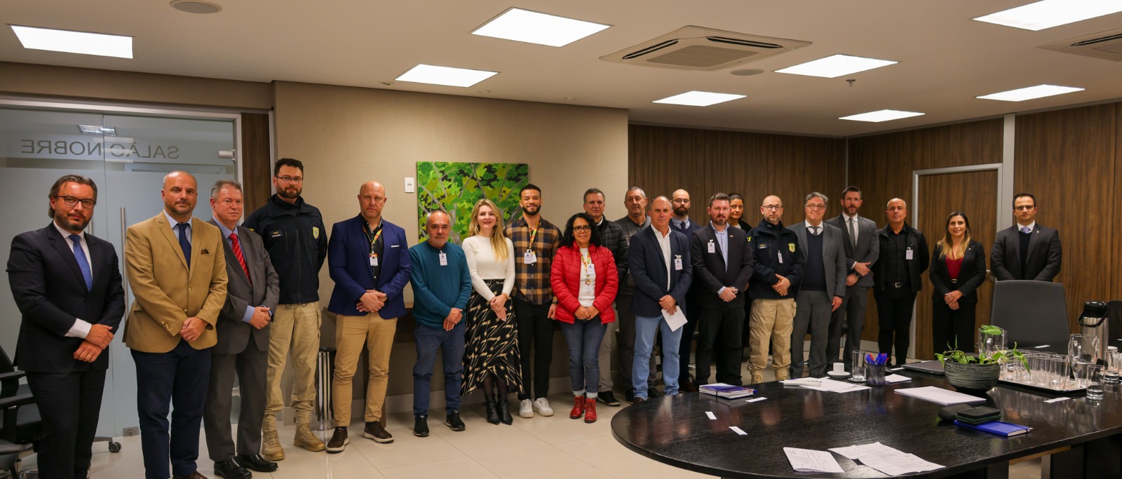 A foto é posada e mostra todos que estavam na reunião de pé.