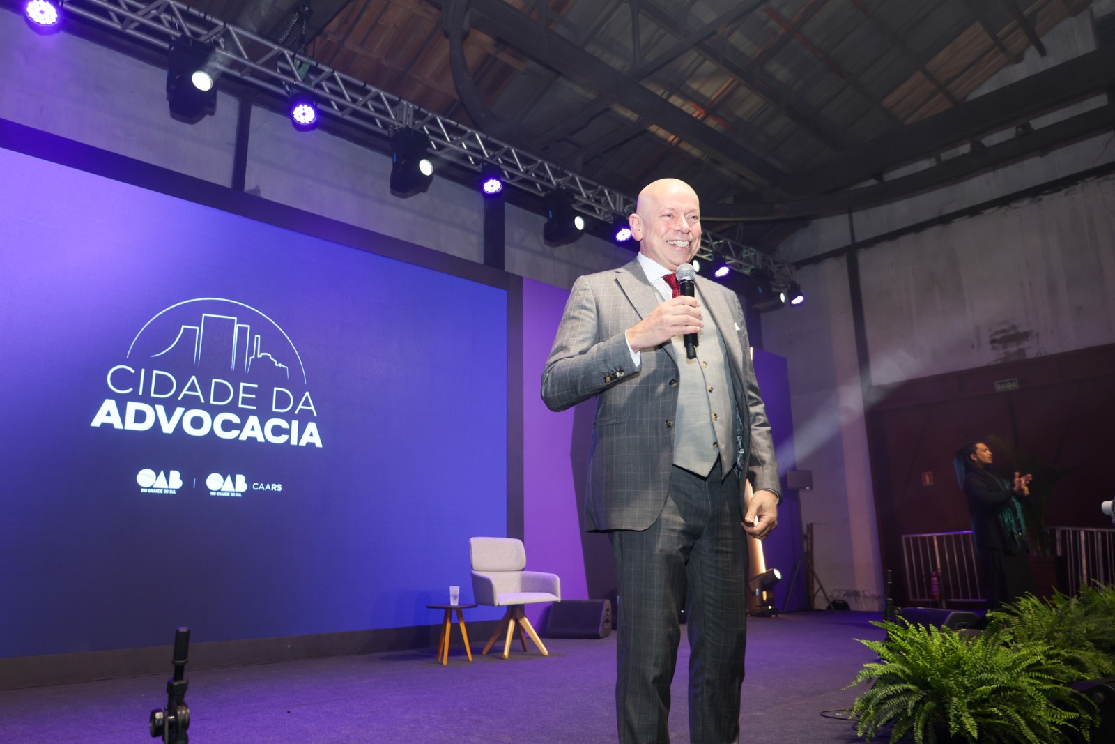 A foto mostra o palestrante Leandro Karnal no palco com microfone