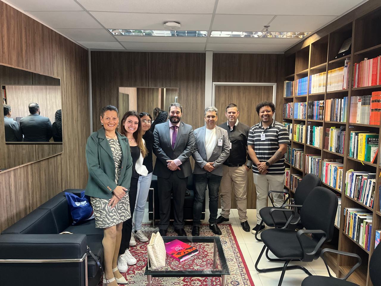 A foto posada mostra o desembargador Alexandre no meio de alunos, em seu gabinete.