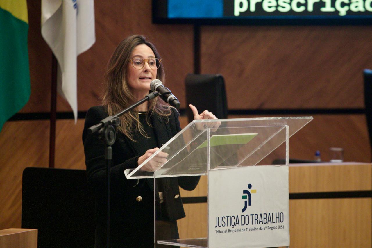 A foto mostra a juíza Luciana palestrando.
