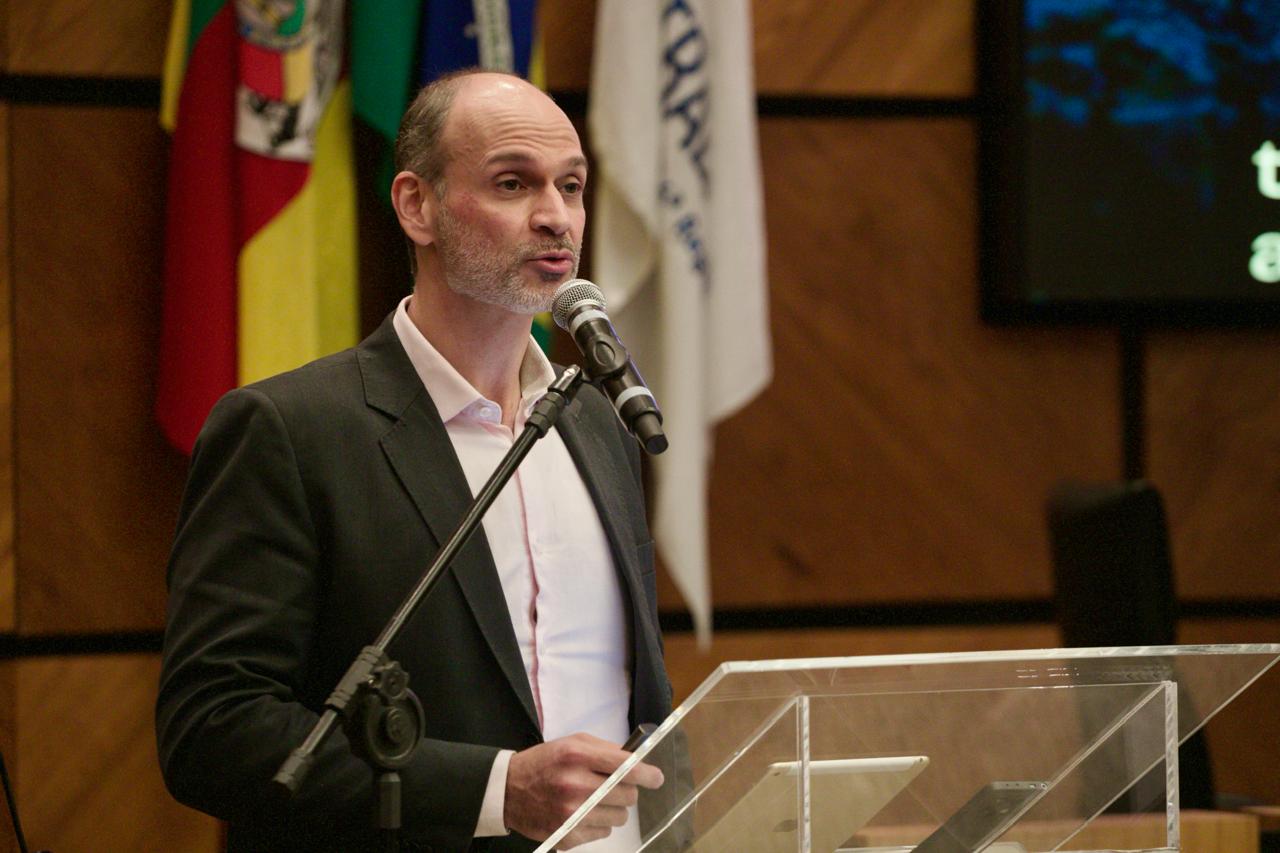 A foto mostra o servidor Gustavo discursando no púlpito.