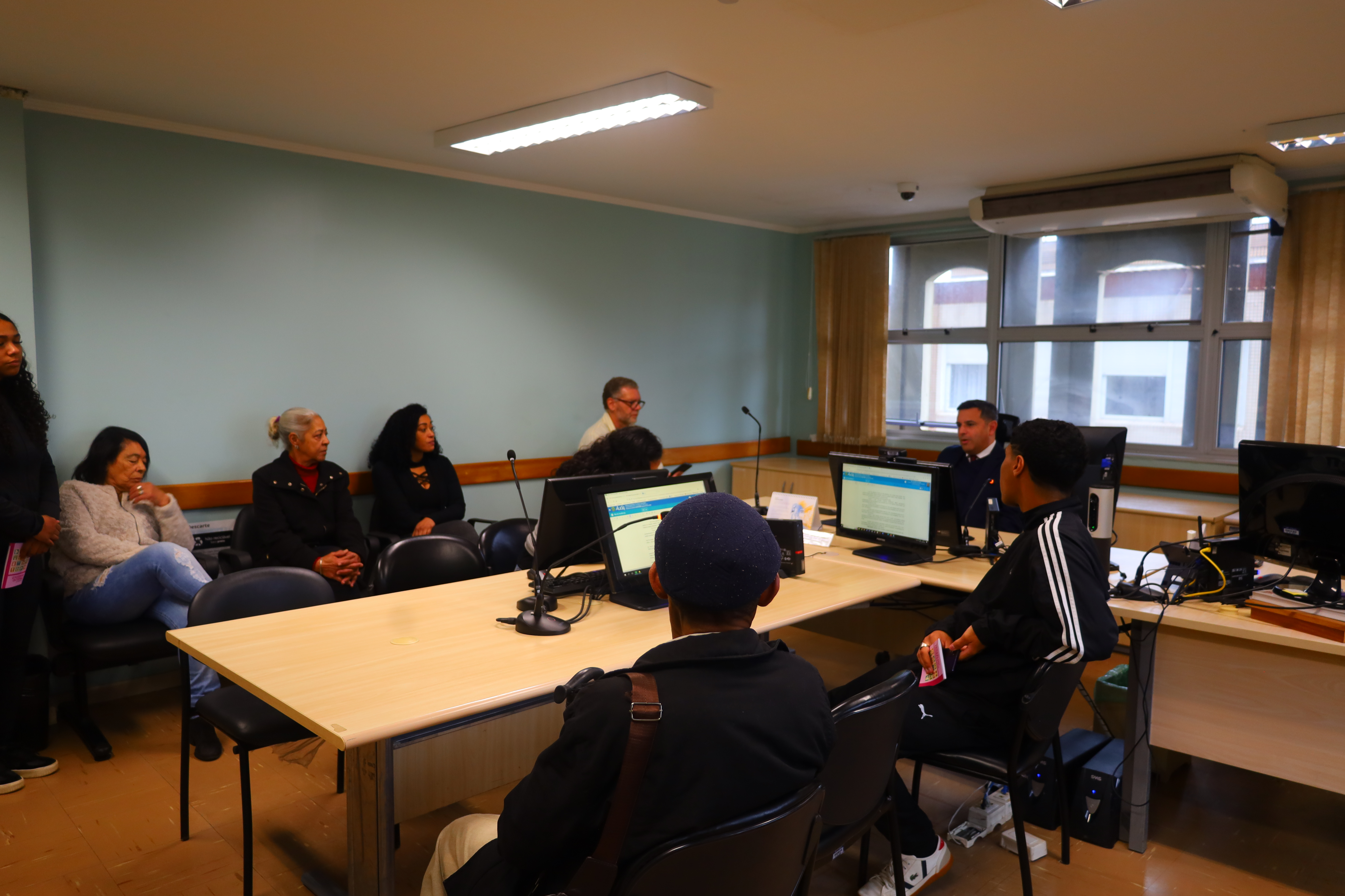 Estudantes na sala de audiência junto com o juiz André.