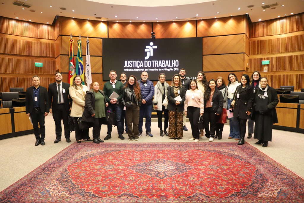 A foto mostra estudantes, servidores e a juíza Mariana posando para foto no meio do plenário do TRT-RS.