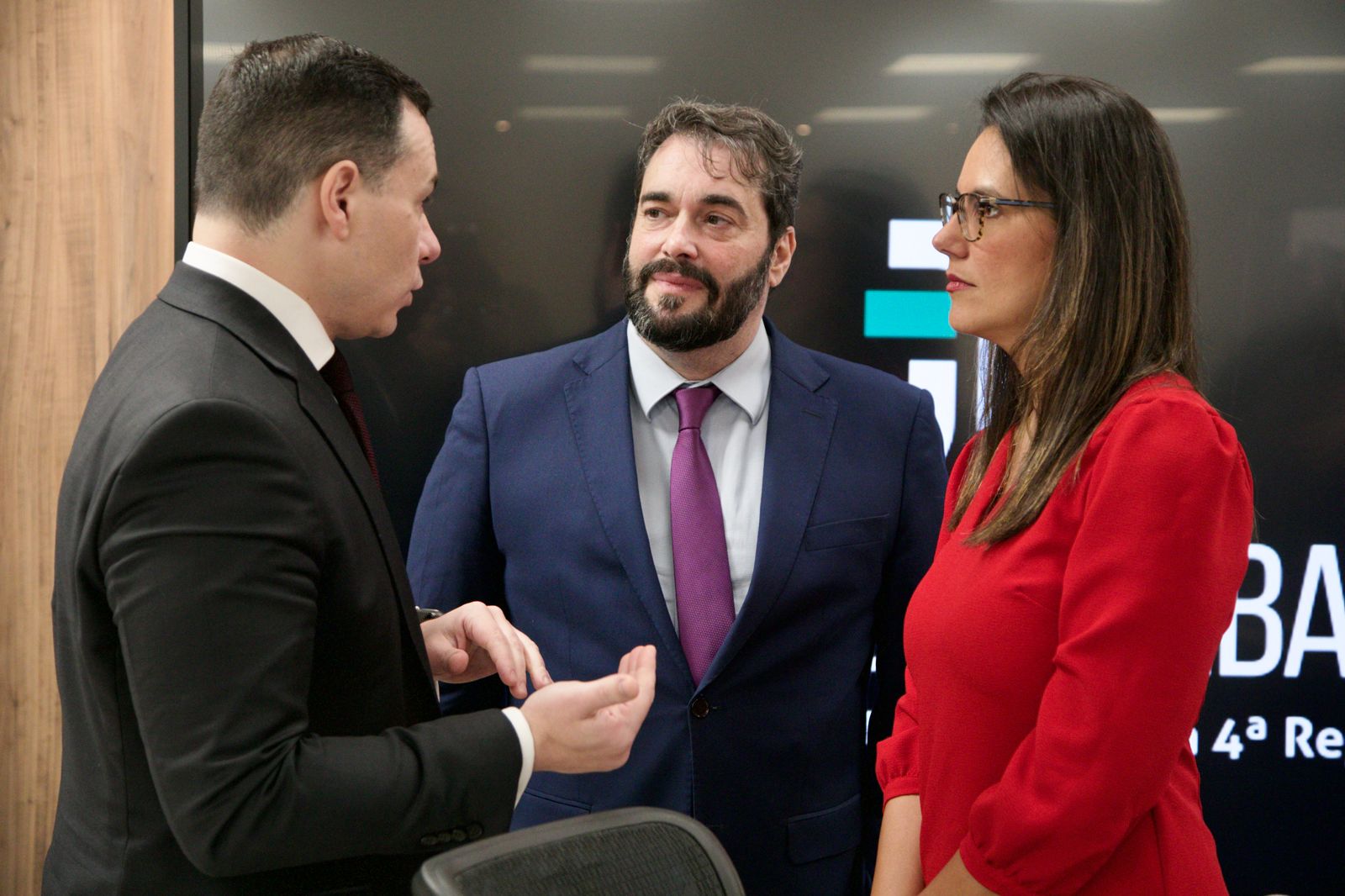 A foto mostra três pessoas conversando.