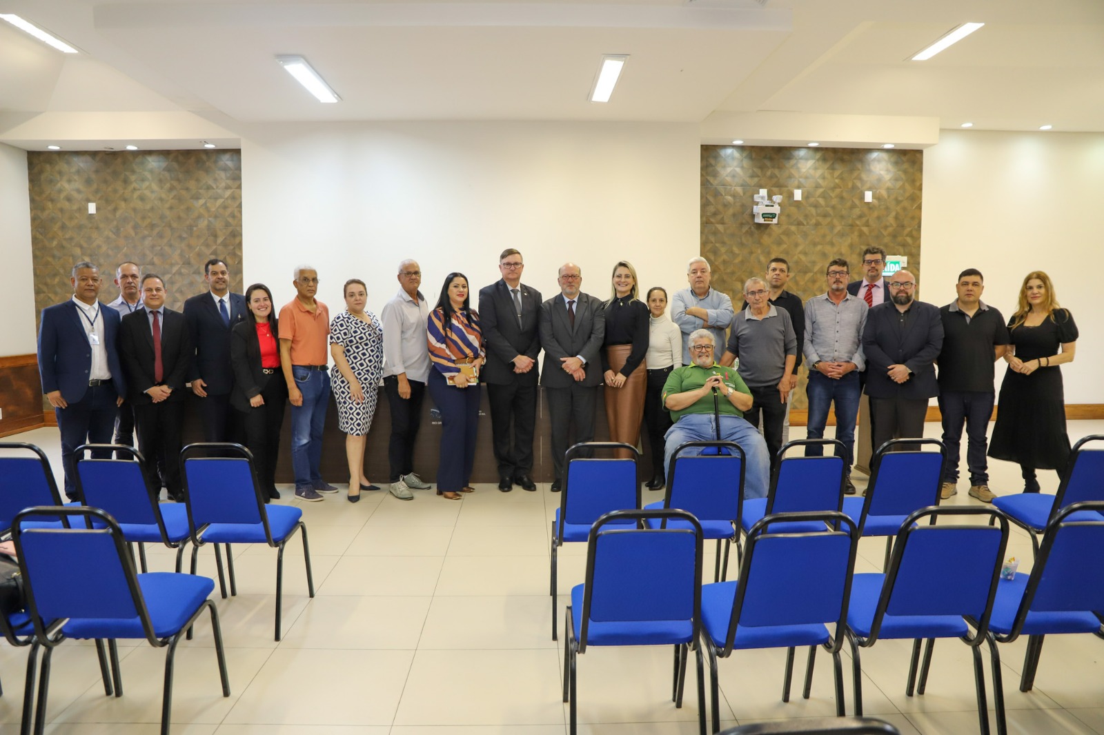 A foto mostra pessoas lado a lado posando para foto.