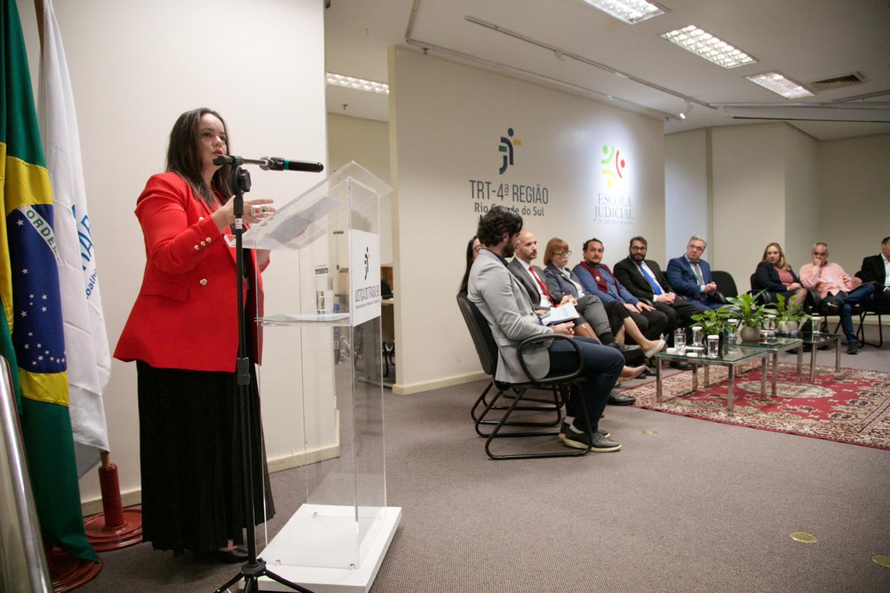 A foto mostra a advogada Caroline discursando.