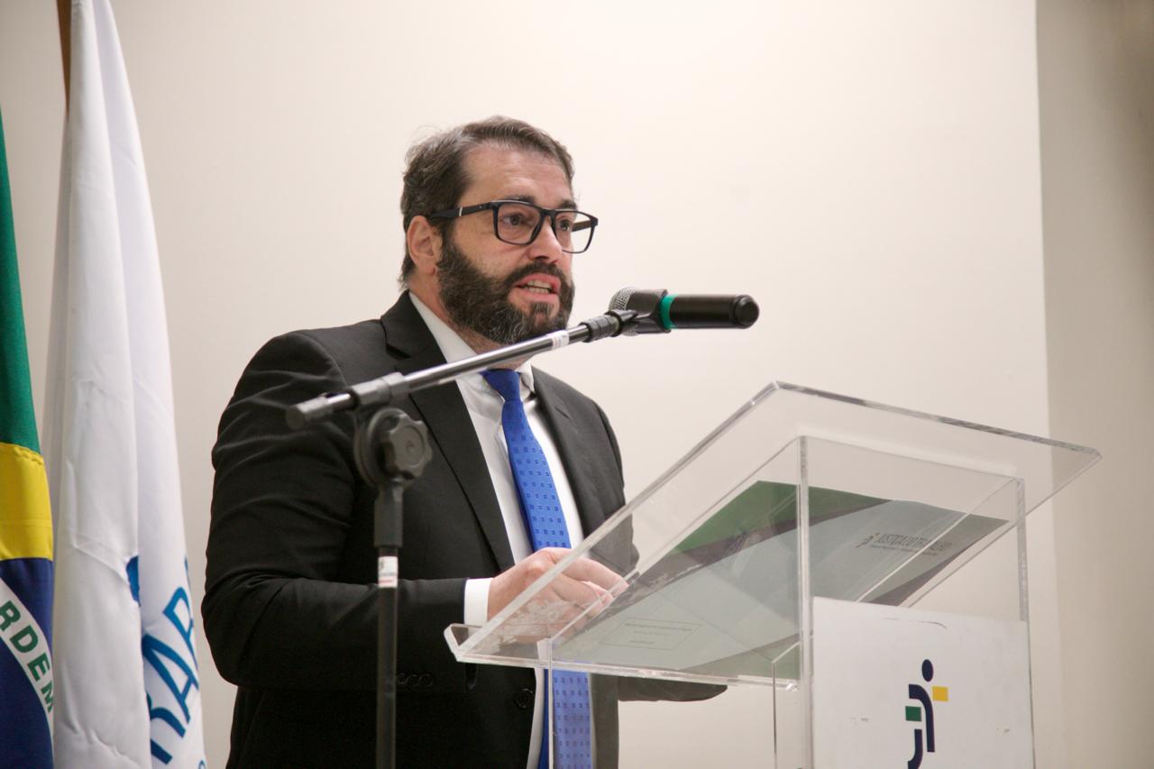 A foto mostra o desembargador Alexandre em primeiro plano discursando.