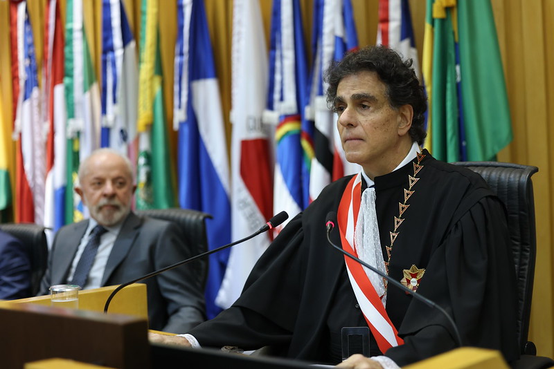 A foto mostra o presidente do TST discursando com lula de fundo.