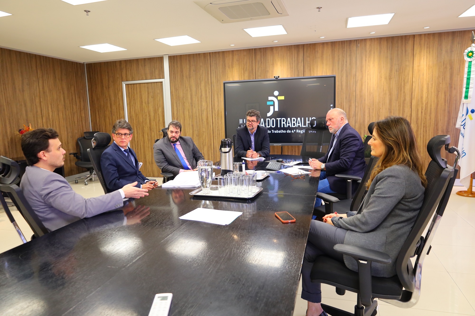 Fotos da reunião, mostrando os participantes sentados à mesa do Salão Nobre, conversando.