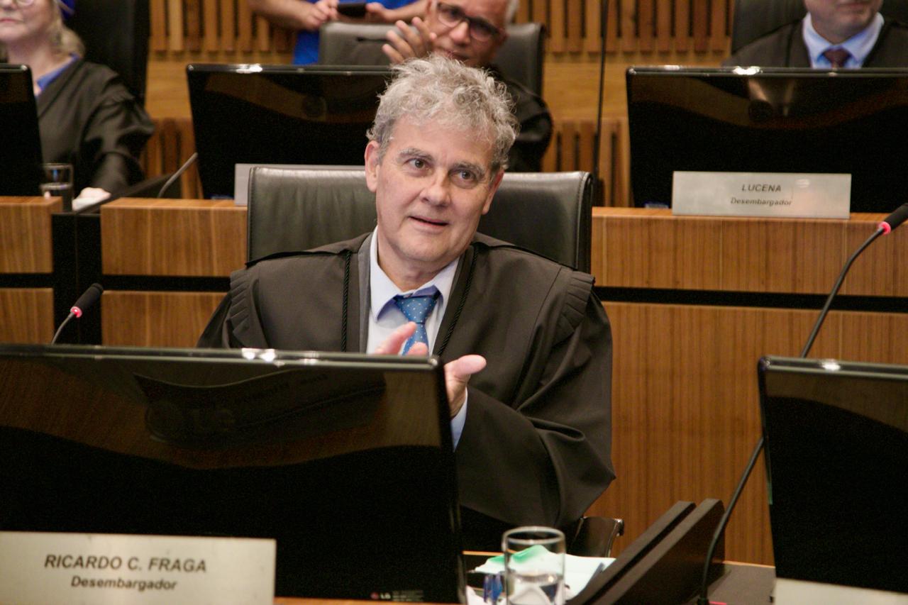 A foto mostra o des. Fraga discursando.