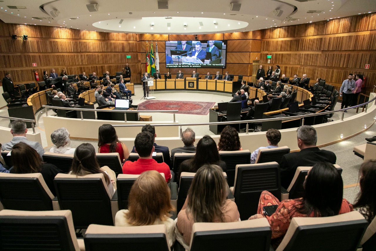 Foto geral do plenário com público em primeiro plano e nave ao fundo com o telão e a mesa de autoridades.