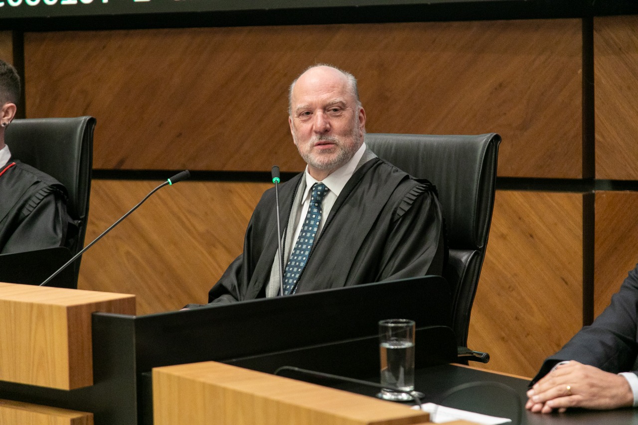Martins Costa é branco e calvo. Está falando e sorrindo, olhando para o lado direito da imagem.