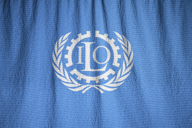 Bandeira azul com brasão em branco, símbolo da Organização Internacional do Trabalho.
